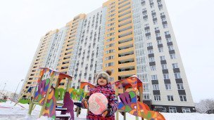 Ребенок гуляет во дворе у дома