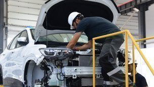 Сотрудник во время работы на автосборочном заводе