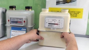 Продавец держит в руках газовый счетчик для домовладений