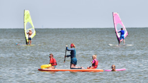 Женщина с детьми на сап-борде в заливе Азовского моря
