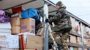 Волонтер во время разгрузки гуманитарной помощи