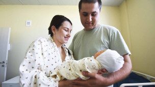 женщина и мужчина с новорожденным ребенком