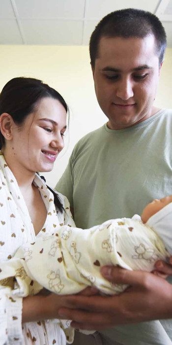 женщина и мужчина с новорожденным ребенком