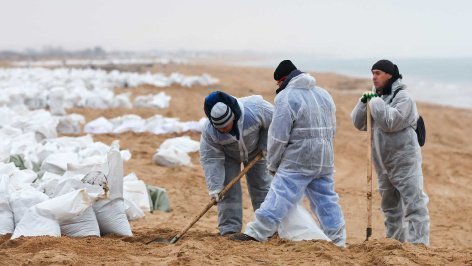 Волонтеры во время уборки разлитого мазута на пляже