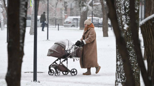 Женщина с коляской в парке