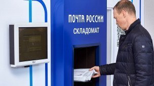 Мужчина у роботизированного пункта приема и выдачи отправлений (складомат)