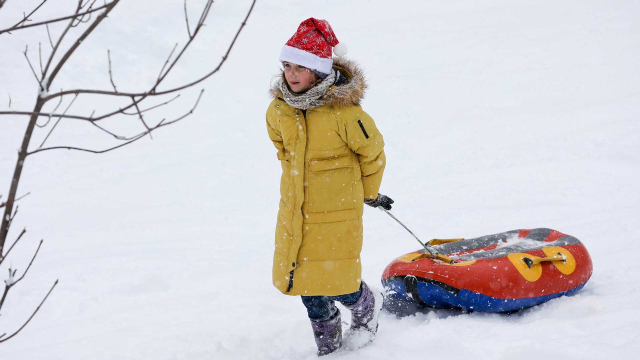 Девочка везет ватрушку на плато Лаго-Наки в Адыгее