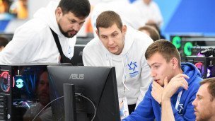 Посетитель и участники фестиваля за компьютером