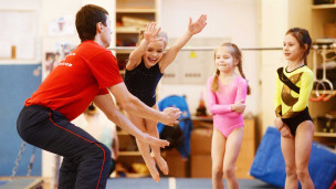 Тренер с детьми на тренировке по гимнастике в спортивном комплексе