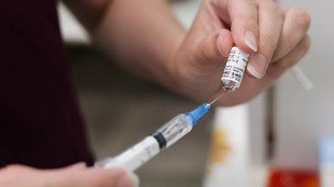 Шприц с вакциной во время профилактической вакцинации 