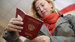 Женщина держит в руках заграничный паспорт РФ