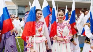 Участницы форума в костюмах с флагами России