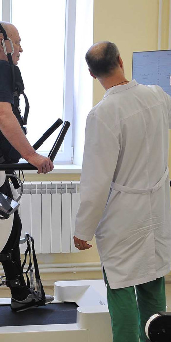 Пациент занимается на роботизированном комплексе для улучшения функций нижних конечностей