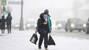 Ребенок на улице с телефоном в снегопад