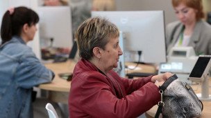 Специалисты с посетителями в отделении банка