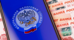 Эмблема ФНС на экране смартфона и пятитысячные купюры