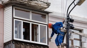  Рабочий во время ремонта фасада здания 