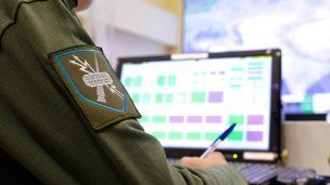 Мужчина в военной форме перед компьютером 