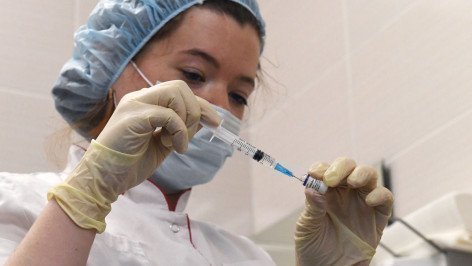 Медицинский сотрудник набирает в шприц вакцину