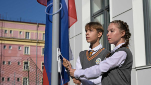Школьники поднимают флаг России