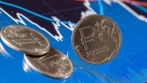 Монеты рубля на фоне биржевого графика
