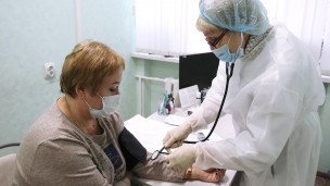 Врач измеряет давления у пациентки 