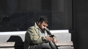 мужчина со смартфоном в руках на лавочке