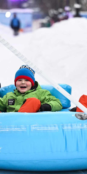 Дети катаются на тюбинге в парке