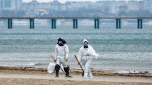 Волонтеры во время уборки разлитого мазута на пляже