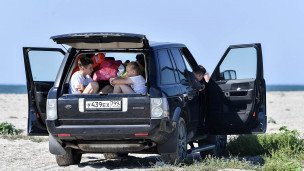 Отдыхающие на пляже в машине