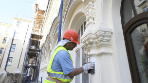 рабочий во время реставрации фасада здания