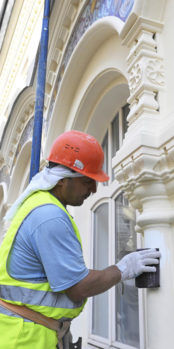 рабочий во время реставрации фасада здания