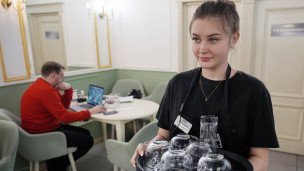 Девушка официантка в ресторане с подносом в руках