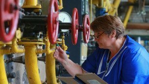 Сотрудница котельной проверяет систему отопления 