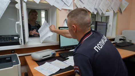Сотрудник отделения полиции передает документы 