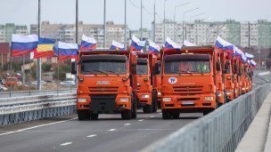 Камазы с российскими флагами едут по новой дороге в России