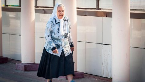 Пожилая женщина идет по улице