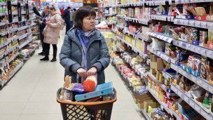 Женщина с тележкой в продуктовом магазине