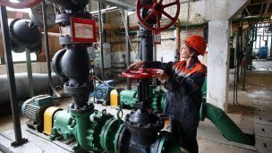 Специалист проверяет регулировку давления в котельной 