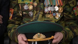Военнослужащий держит фуражку в руках