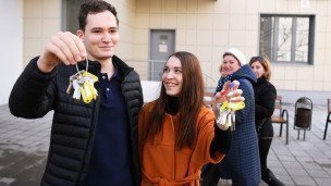 Люди с ключами возле многоэтажного жилого дома