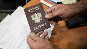 Мужчина держит в руках российский паспорт 