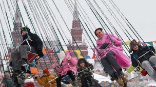Москвичи и гости города катаются на каруселях на Красной площади
