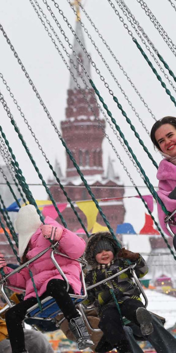 Москвичи и гости города катаются на каруселях на Красной площади