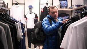 Покупатель выбирает одежду в магазине