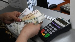 Женщина пересчитывает деньги в мобильном офисе Центробанка