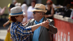 Пожилые мужчина и женщина танцуют в парке