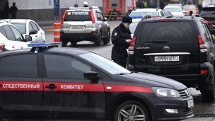 Сотрудник полиции и машина следственного комитета РФ у концертного зала "Крокус Сити Холл"
