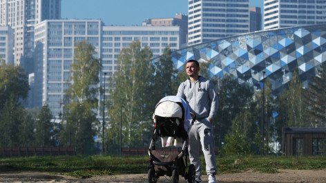 Мужчина с коляской на фоне новостроек 