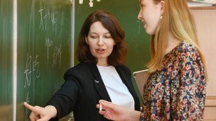 учитель с ученицей у доски во время урока